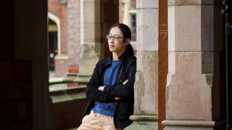 student leaning against a wall at Queen's University